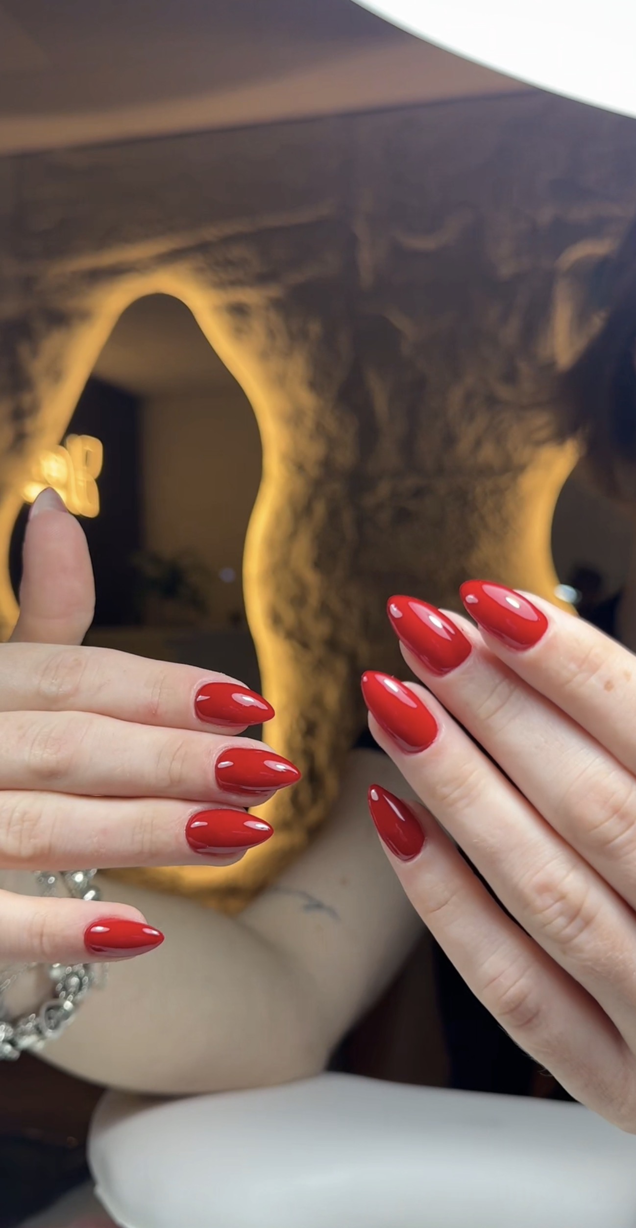 Rode nagels in amandelvorm voor de verlichte spiegel